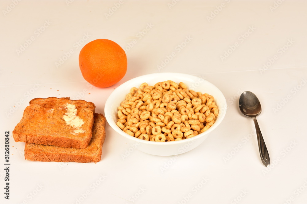 Oats cereal in bowl with buttered toast and orange. Oats cereal in bowl with buttered toast and orange.
