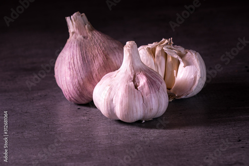 three large heads of pink garlic on a kitchen worktop
