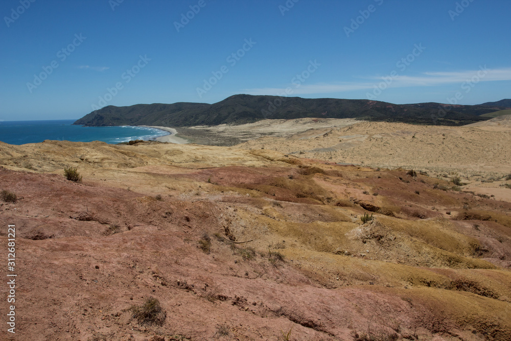 The moon-like colored clay hills of the New Zealand's Cape Reinga in Northland, and Te Werahi Beach The moon-like colored clay hills of the New Zealand's Cape Reinga in Northland, and Te Werahi Beach