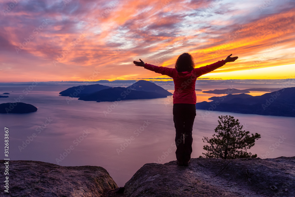 Adventurous Caucasian Girl standing on top of a mountain during a colorful winter sunset. Taken on Tunnel Bluffs Hike, North of Vancouver, BC, Canada. Adventurous Caucasian Girl standing on top of a mountain during a colorful winter sunset. Taken on Tunnel Bluffs Hike, North of Vancouver, BC, Canada.