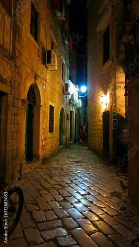 Medieval vintage narrow street with ancient stone pavers in old european city Kotor in Montenegro at night