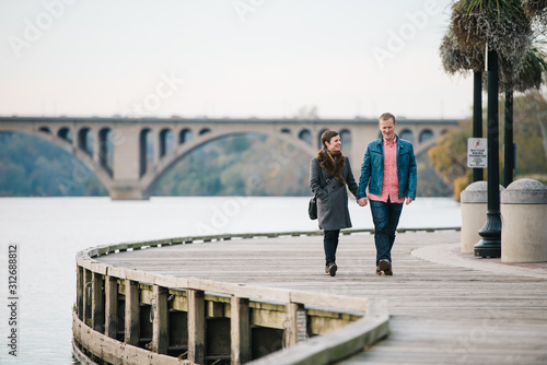 Couple holding hands and walking along the boardwalk in Georgetown, Washington DC photo