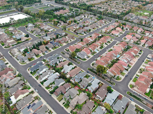 Aerial view of urban sprawl. Suburban packed homes neighborhood with road. Vast subdivision in Irvine  California  USA