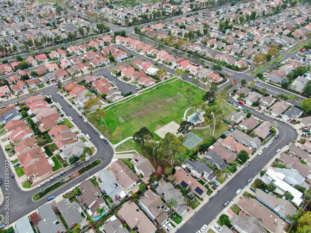 Aerial view of urban sprawl. Suburban packed homes neighborhood with road. Vast subdivision in Irvine, California, USA