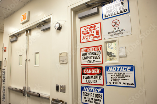 Warning signs on door at chemical plant