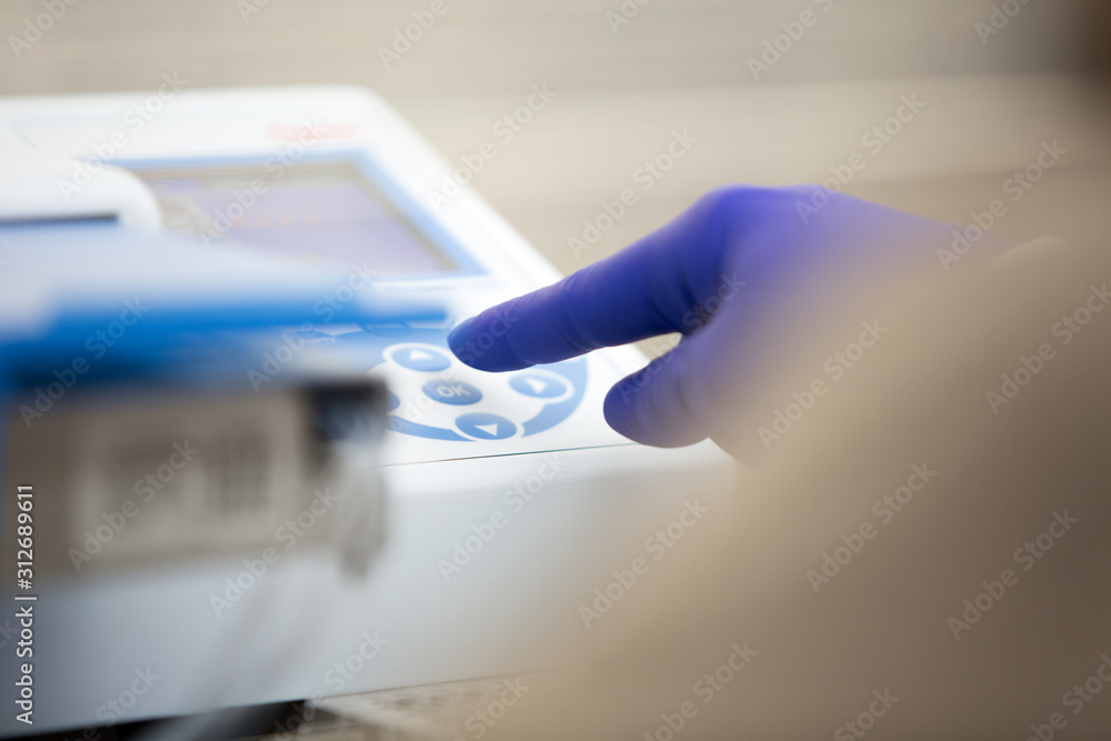 Laboratory worker's hand wearing glove starting device