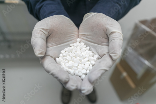 Midsection of scientist holding pills at Brookhaven National Laboratory photo