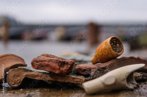 Mudlark findings of the past: an old clay pipe bowl, found while mudlarking on the River Thames in London, England  photo