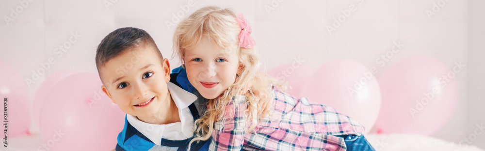 Happy Caucasian funny children hugging. Best friends forever. Valentine Day holiday concept. Web banner header for website. Boy and girl kids having fun. Love and friendship. Happy Caucasian funny children hugging. Best friends forever. Valentine Day holiday concept. Web banner header for website. Boy and girl kids having fun. Love and friendship.
