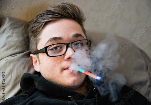 teen is using vape with thc oil for the first time photo