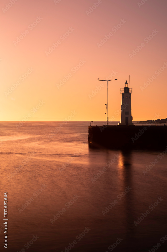 Waterfront Anstruther, fife, scotland. pier with lighthouse at sunset.