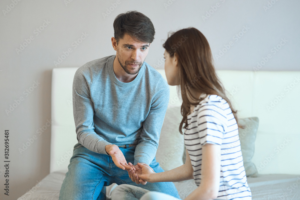 couple sitting on sofa and looking at each other couple sitting on sofa and looking at each other