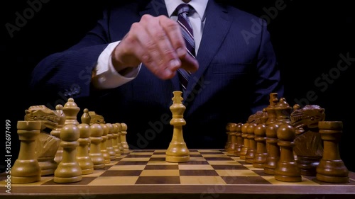 Confident Business Leader Places King on Chess Game Board photo