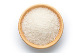 The rice of northeast China in a wooden bowl on white background. Top view.