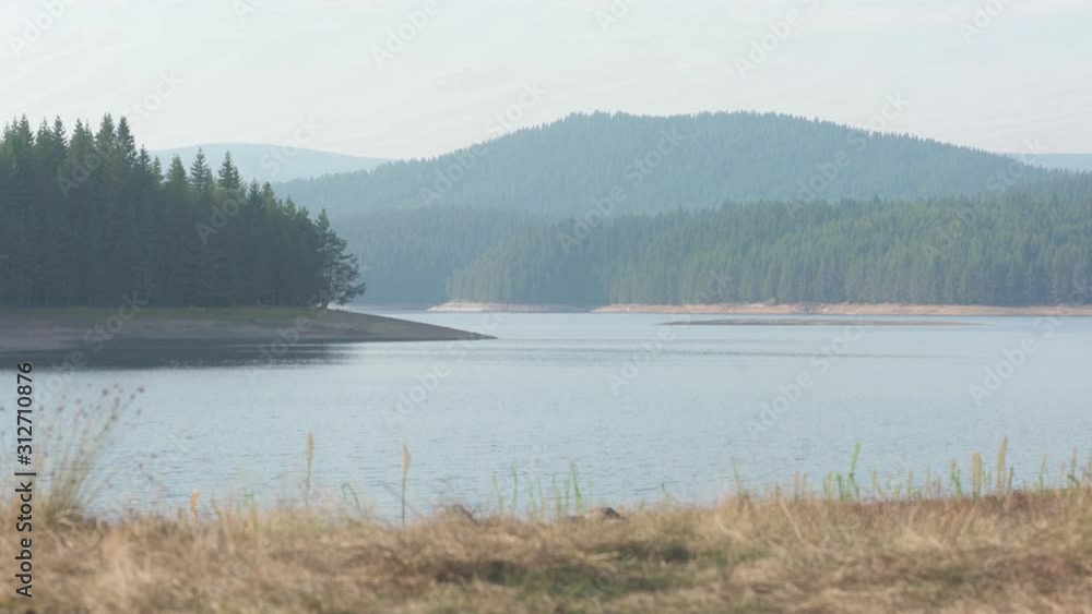 A calming scene of a beautiful mountain lake and the surrounding forests and hills. Beauty and serenity captured deep in the mountainous regions of south-east Europe. A calming scene of a beautiful mountain lake and the surrounding forests and hills. Beauty and serenity captured deep in the mountainous regions of south-east Europe.