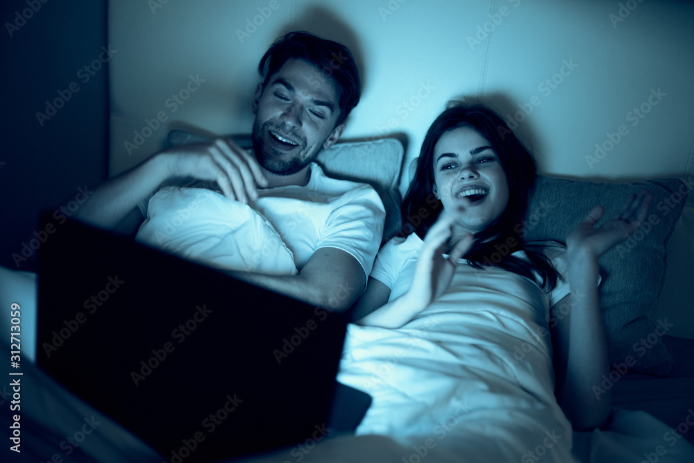 young couple sitting on sofa and watching tv young couple sitting on sofa and watching tv