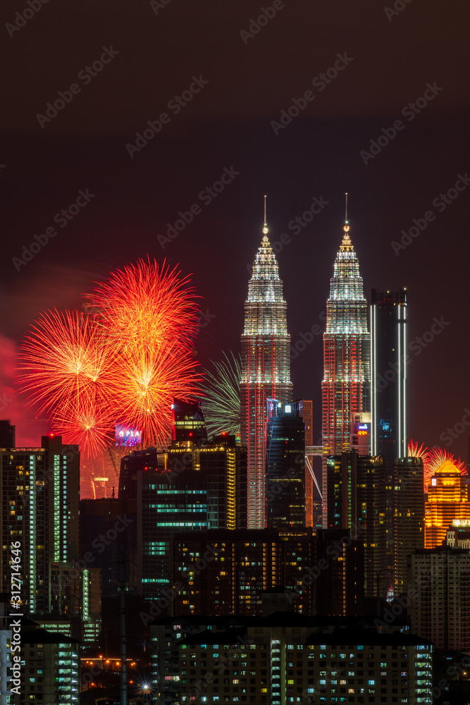 KUALA LUMPUR, MALAYSIA - 1ST JANUARY 2020; Fireworks explode near Malaysia's landmark Petronas Twin Towers during New Year celebrations in Kuala Lumpur.