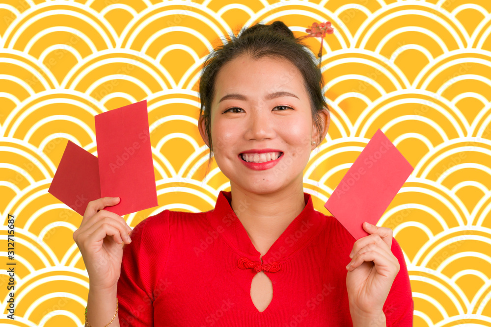 young happy and beautiful Asian Chinese woman in traditional New Year red dress and hair bun holding red pocket envelopes with money as blessing from friends and family young happy and beautiful Asian Chinese woman in traditional New Year red dress and hair bun holding red pocket envelopes with money as blessing from friends and family