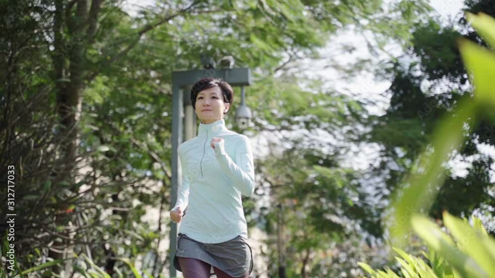 Asian beauty jogging outdoor in city park slow motion Asian beauty jogging outdoor in city park slow motion