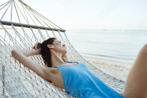 woman in hammock on a background of blue sky and clouds © SHOTPRIME STUDIO