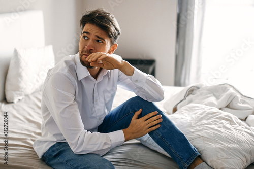 man sitting on sofa at home