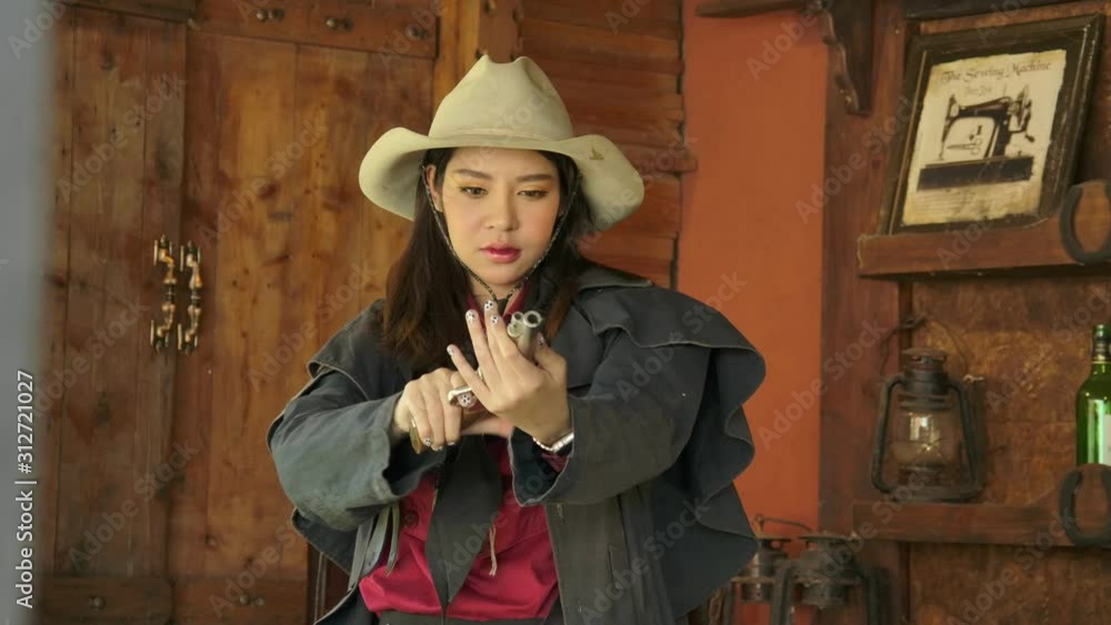 A young Asian Cowgirl play the revolver gun in the counter whisky bar
