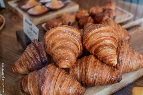 freshly baked croissants on wooden cutting board Warm Fresh Buttery Croissants and Rolls. French and American Croissants and Baked Pastries
