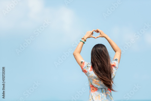 Summer Vacation. Traveler women relaxing and raise hand heart shape joy fun on the beach, so happy and luxury and destination in holiday summer. Tourism chill on sand.