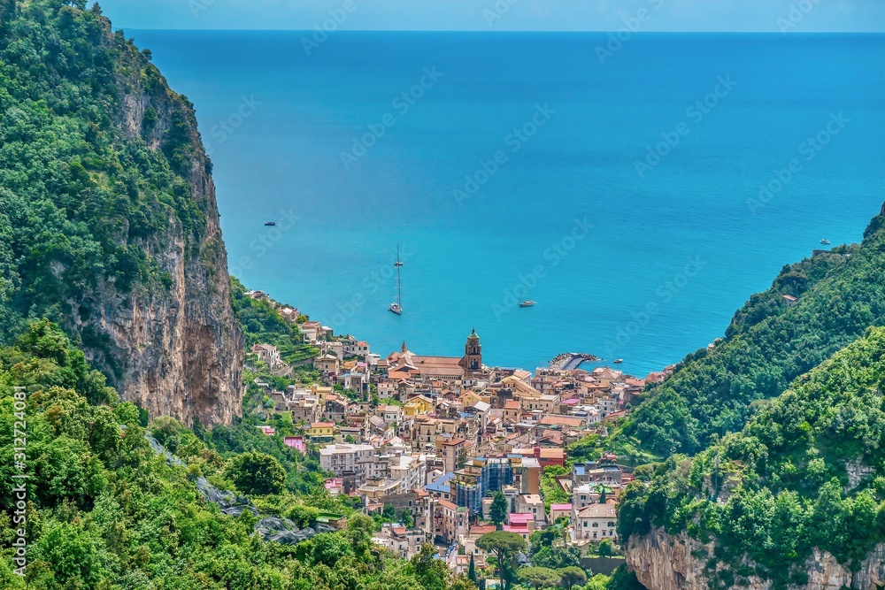 A high angle view of the beautiful coastal town of Amalfi, Italy, with its dramatic natural setting of steep cliffs and Mediterranean Sea views.