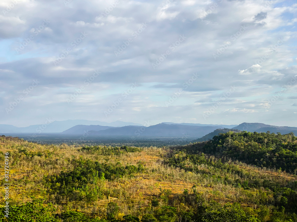 Landscape view of forest, mountain, and cloudy sky at border of Thailand and Lao