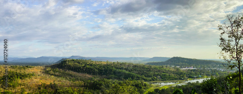 Landscape view of forest, mountain, and cloudy sky at border of Thailand and Lao