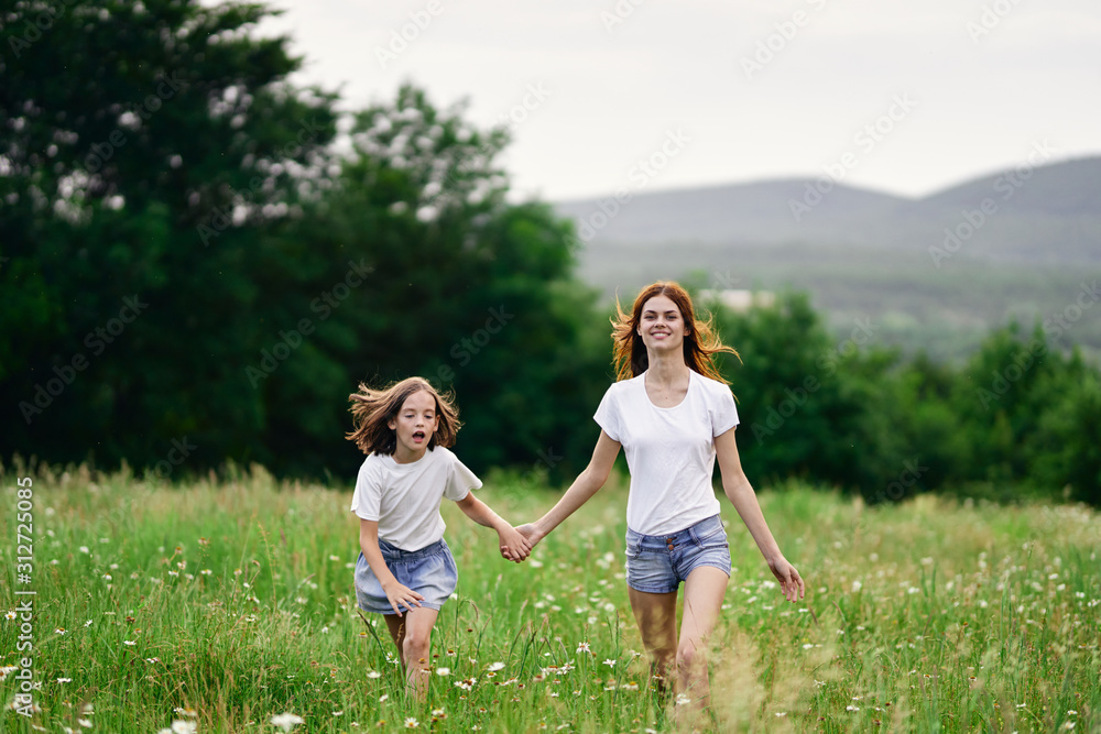 mother and daughter running in the field mother and daughter running in the field