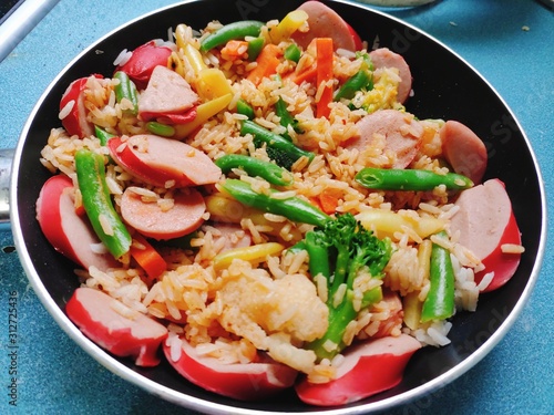 Com Chien - Delicious fried rice with egg jam ham chicken Vietnamese traditional food asian cuisine in black cast iron pan