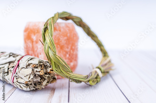 Items used to purify or cleanse home of bad energy and attract good energy. On wood table with white background, bright and airy. Closeup with blurred background