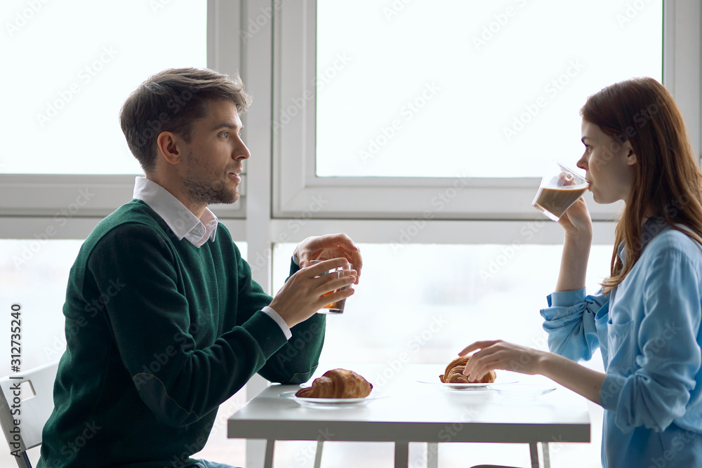 young couple having breakfast in the kitchen