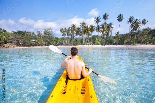 kayaking on tropical beach, travel to Asia, summer holidays, tourist paddling on kayak in turquoise sea water