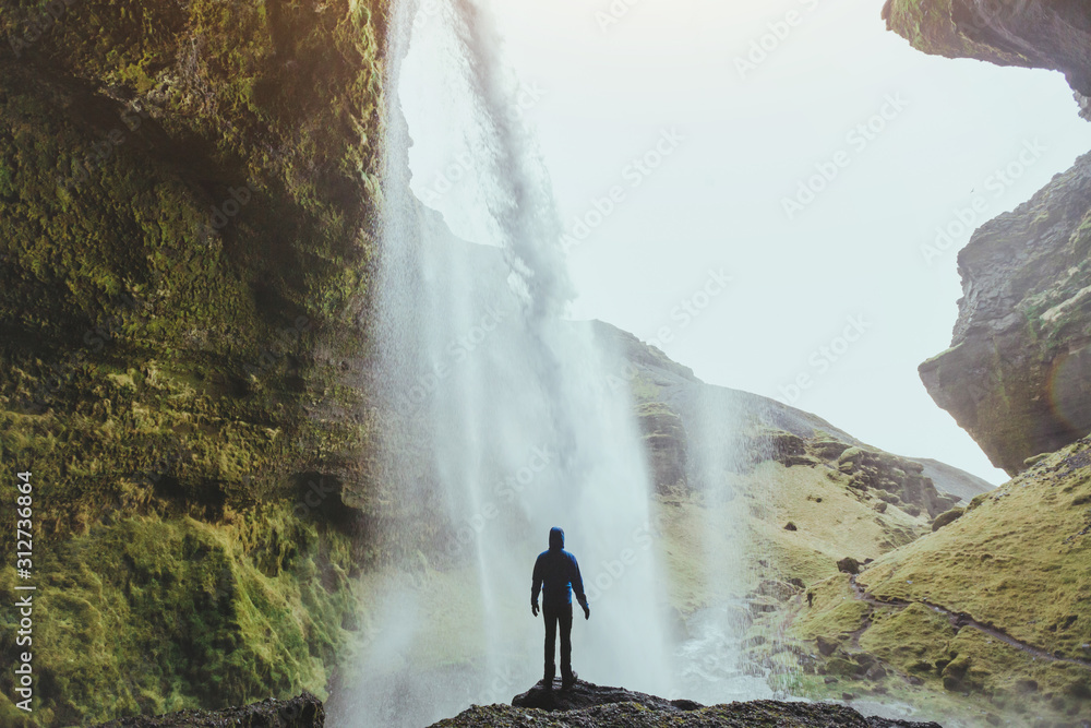 outdoor adventure, person standing near waterfall Kvernufoss in Iceland, nature landscape - obrazy, fototapety, plakaty 