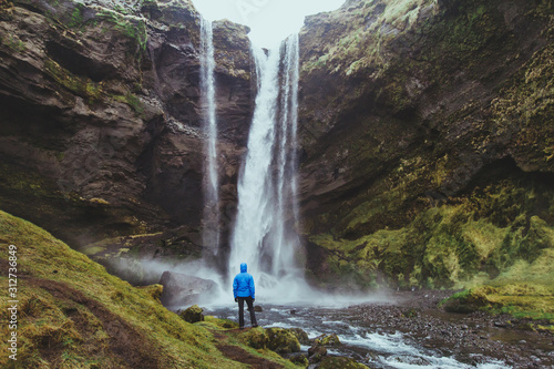 outdoor travel, tourist looking at waterfall landscape in Iceland