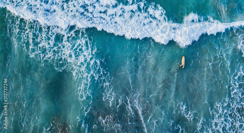 surfer in the ocean top down aerial view in blue waves, banner background photo