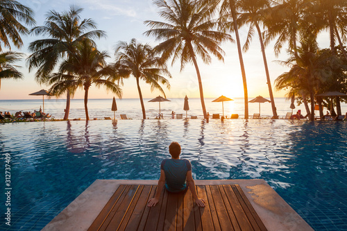 summer holiday getaway in luxury beach hotel, tourist relaxing near luxurious swimming pool at sunset, vacation on tropical island © Song_about_summer