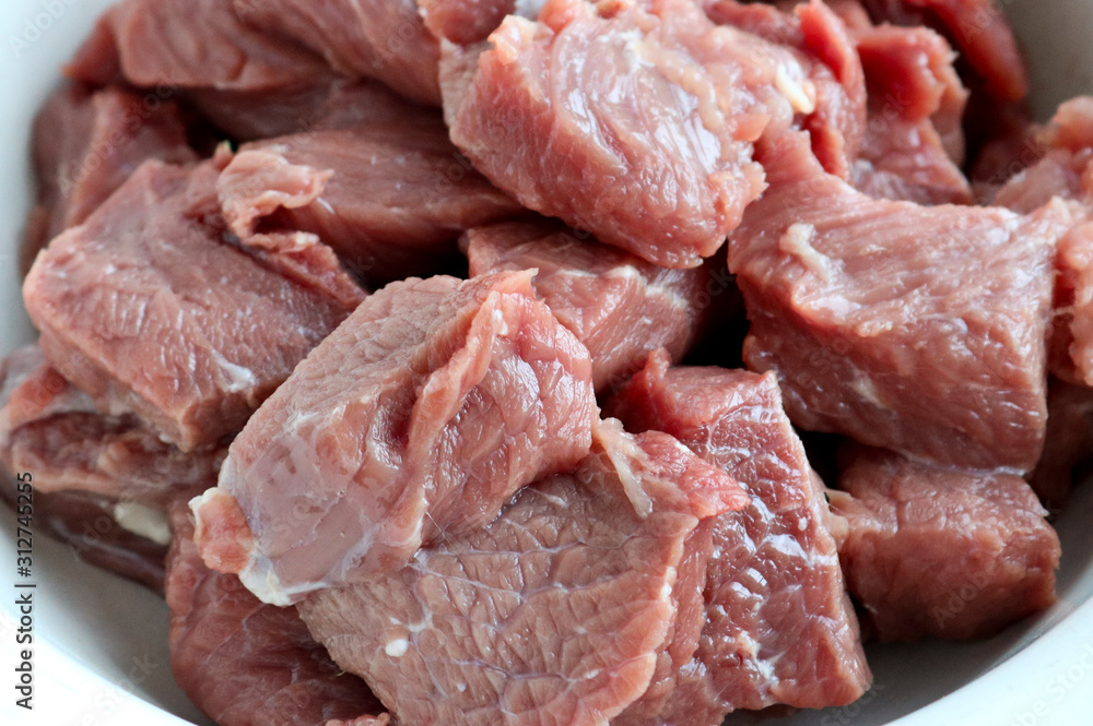 Coarsely chopped pieces of beef. The concept of cholesterol food.  Raw meat before cooking.