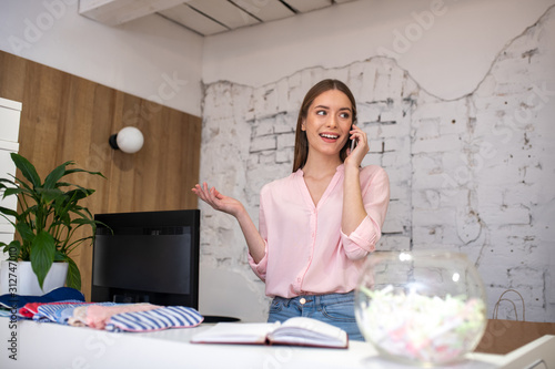 Woman near the counter making a phone call photo