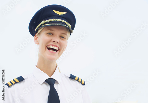happy female pilot laughing in uniform. Professional pilot woman smiling at work.
