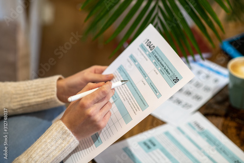 Woman holding the paper for counting tax expenses photo