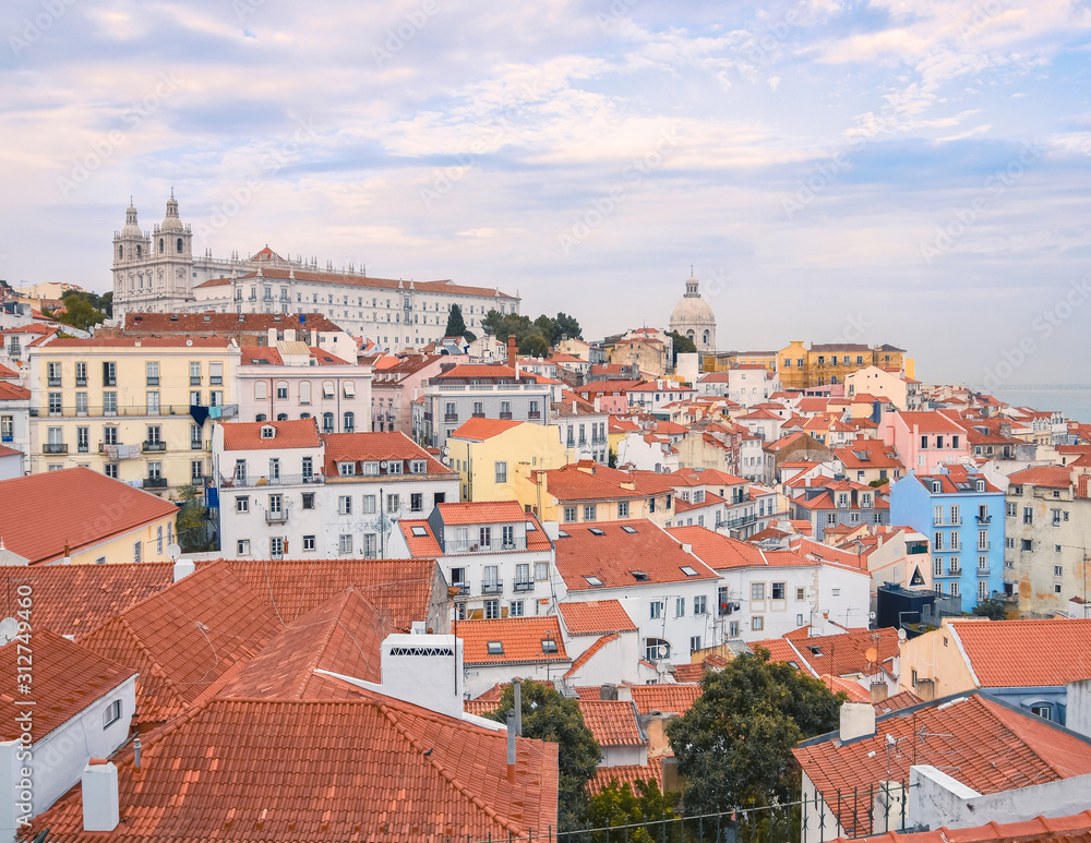 Lisbon panoramic view.  walls of the buildings of Lisbon, with orange roofs and the Church of Sao Vicente of Fora in the background. Sunny dayand blue sky in summer. Travel and real estate concept. Li