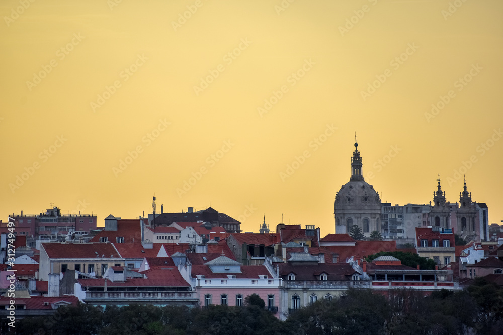 Lisbon skyline view. Colorful walls of the buildings of Lisbon, with orange roofs and the Basílica da Estrela at sunset. Travel and real estate concept. Lisbon, Portugal. Europe.