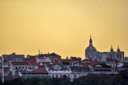 Lisbon skyline view. Colorful walls of the buildings of Lisbon, with orange roofs and the Basílica da Estrela at sunset. Travel and real estate concept. Lisbon, Portugal. Europe.