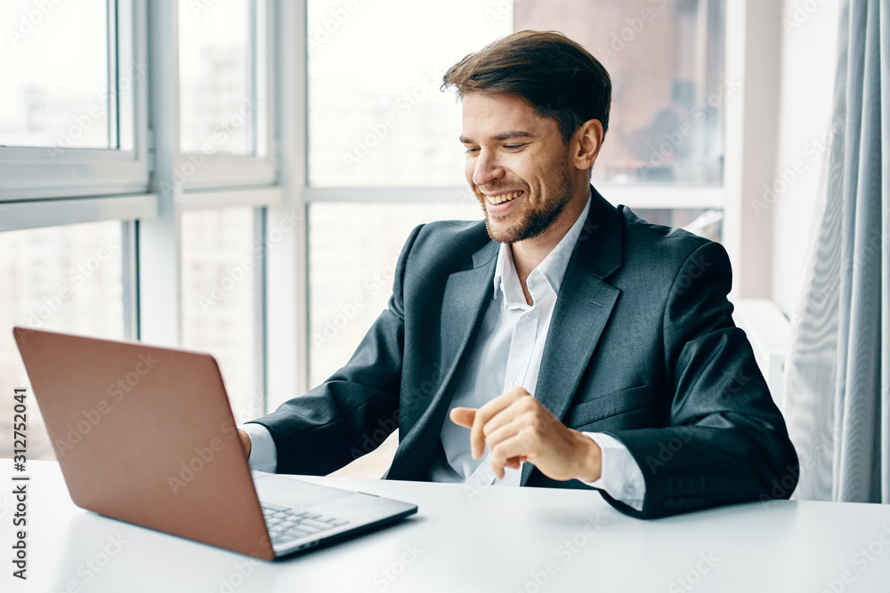 young businessman sitting at desk in office young businessman sitting at desk in office