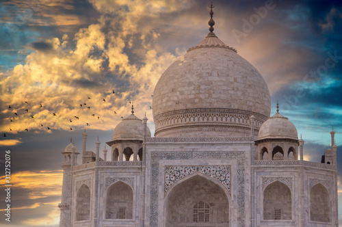 Beautiful Taj Mahal during sunset with birds circling it