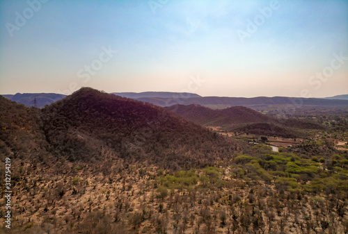 A road through dry and lower mountains in the desert. Aerial view of  a road through low altitude mountains